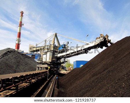Stacker with a heap of coal next to the plant