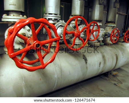 Pipes and valves with red knobs for hot water