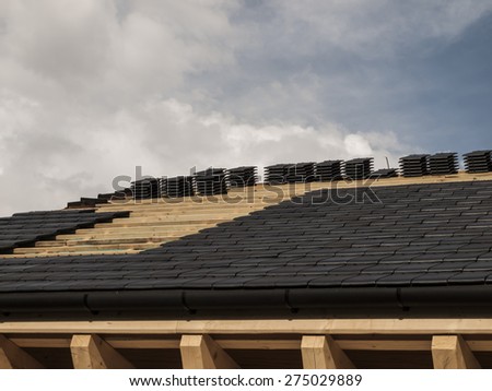 construction, laying ceramic tile roof on wooden house