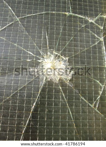 smashed reinforced glass in the window of an old factory hall metal plant