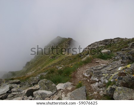 stony, alpine, tourist trail mountain during bad weather, in fog