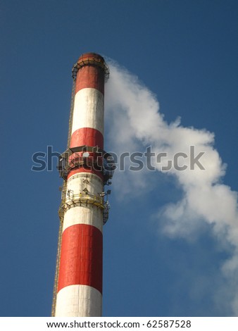 red and white chimney with outgoing exhaust gases or steam