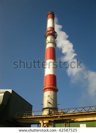 red and white chimney with outgoing exhaust gases or steam