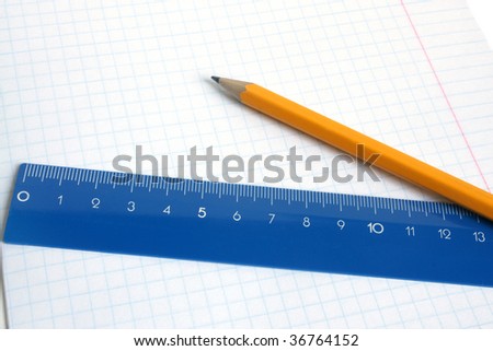 Lead pencil and blue ruler on a school writing-book
