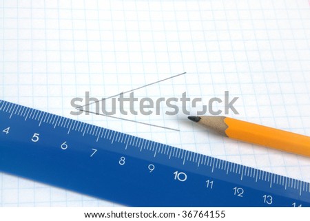 Lead pencil and blue ruler on a school writing-book