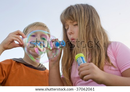 boy and girl make soap bubbles