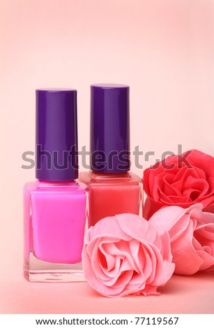 stock photo : Nail polish bottles and rose flowers on pink background