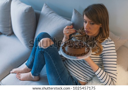 Depressed woman eats cake.  Sad unhappy woman eating cake. Sad woman eating sweet cake. Close up of woman eating chocolate cake. food, junk-food, culinary, baking and holidays concept