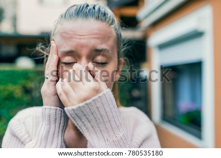 Sinus ache causing very paintful headache. Unhealthy woman in pain. Sharp strong sore. Sinus pain, sinus pressure, sinusitis. Sad woman holding her nose and head because sinus pain