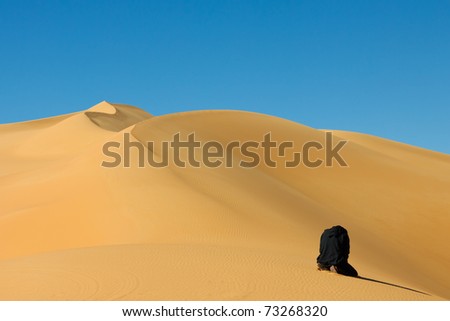 stock photo Muslim man praying in the desert Awbari Sand Sea Sahara