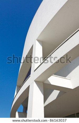 Modern architecture - curved white building against blue sky.