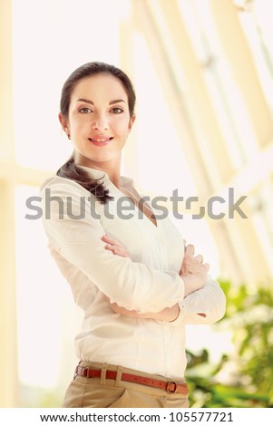Portrait of a beautiful young woman with folded arms