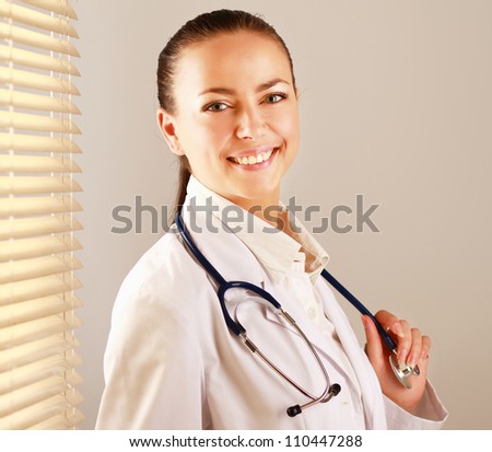 Woman doctor is standing near window