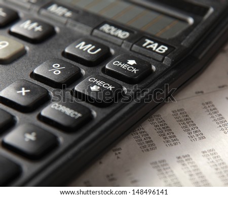 Close-up of  pen and calculator on paper table numbers.