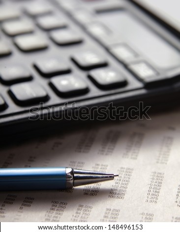 Close-up of pen and calculator on paper table numbers.