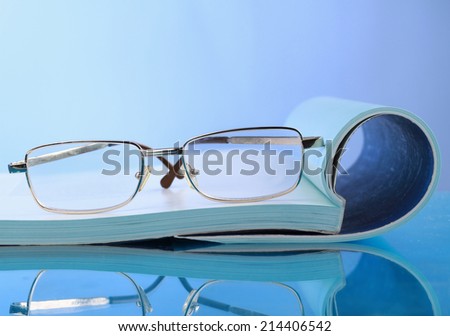 Open journals with glasses in front