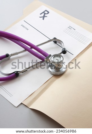 A stethoscope and RX prescription are lying on a medical uniform.