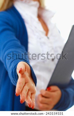 Young woman with folder offering handshake isolated. Focus on hand