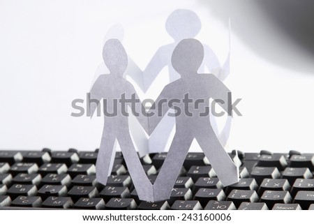 A circle of paper cutted people with clipping path on a keyboard