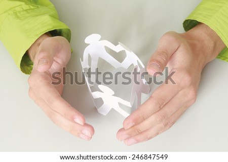 Male hands taking care of paper people