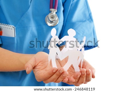 A female doctor holding paper people, focus on the hands