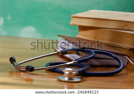 Books, a stethoscope and an organizer on a wooden desk