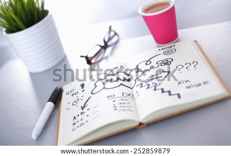 Note book with cup lying on the desk
