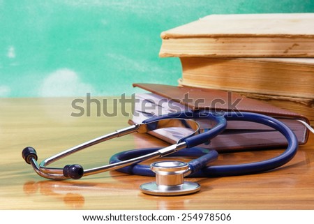Books, a stethoscope and an organizer on a wooden desk