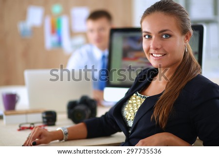 Female photographer sitting on the desk with laptop
