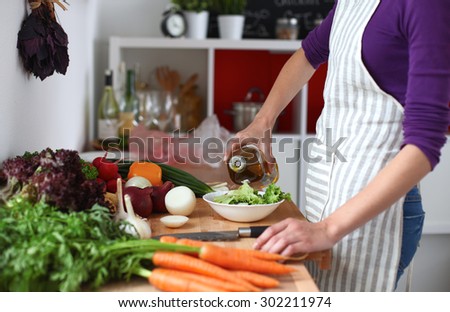 Young woman mixing fresh salad ,oil recharge