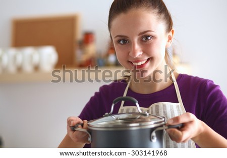 Youn woman holding pan in hands on kitchen