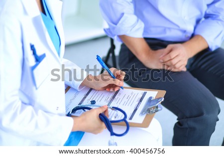 Doctor woman sitting with  male patient at the desk