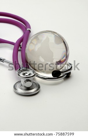 Stethoscope next to glass globe world map