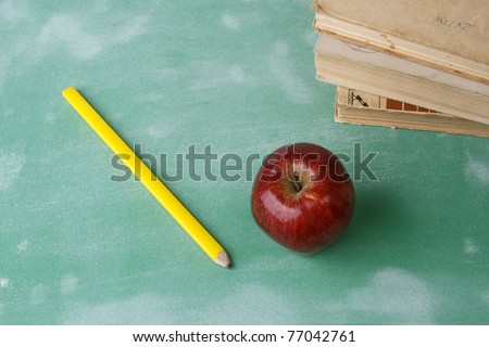 A chalkboard with an apple, a pencil and books