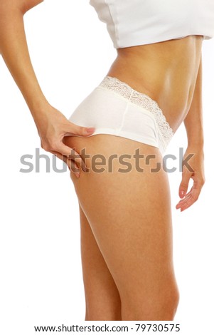 A young woman pampering cellulite skin on her legs, isolated on white