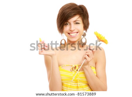 A smiling woman torn a petal from yellow gerbera, isolated on white background