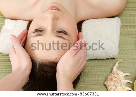Beautiful young woman in spa. Facial massage. Top view