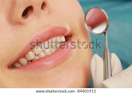 A young woman / teenager with open mouth at the dentist, indoors