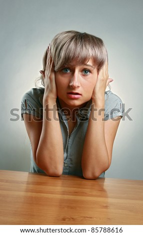 Hear no evil - Young woman covering her ears with hands over white background