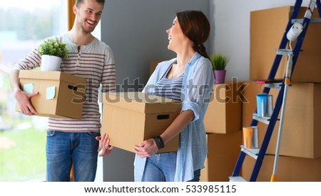Happy young couple unpacking or packing boxes and moving into a new home