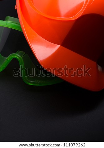 Red safety helmet with goggles on black