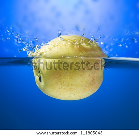 Yellow apple in water splash