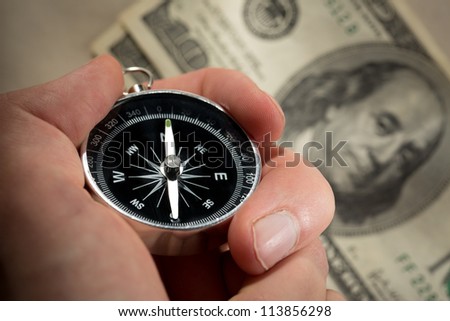 Hand holding silver black compass