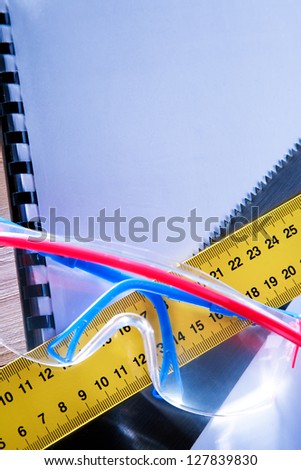Ruler, notebook, handsaw and goggles