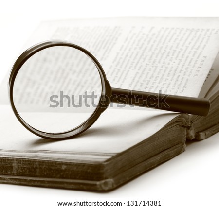 Magnifying glass and old book on the white background