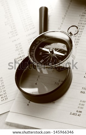 Operating budget, magnifying glass and black compass