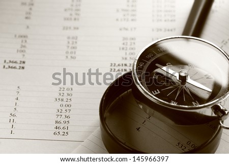 Operating budget, magnifying glass and black compass