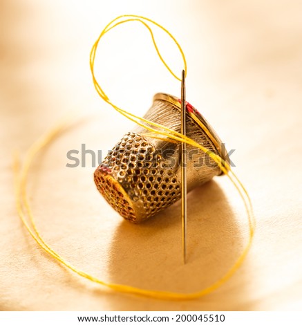 Metal sewing thimble and needle with thread