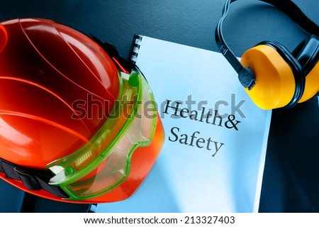 Safety goggles, earphones and red helmet