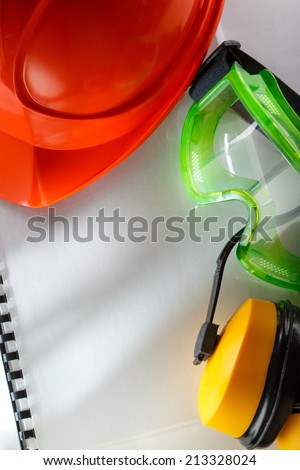 Safety goggles, earphones and red helmet